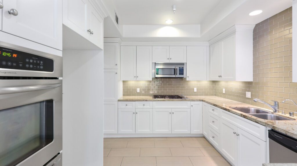 Kitchen with complete appliances and white cabinets